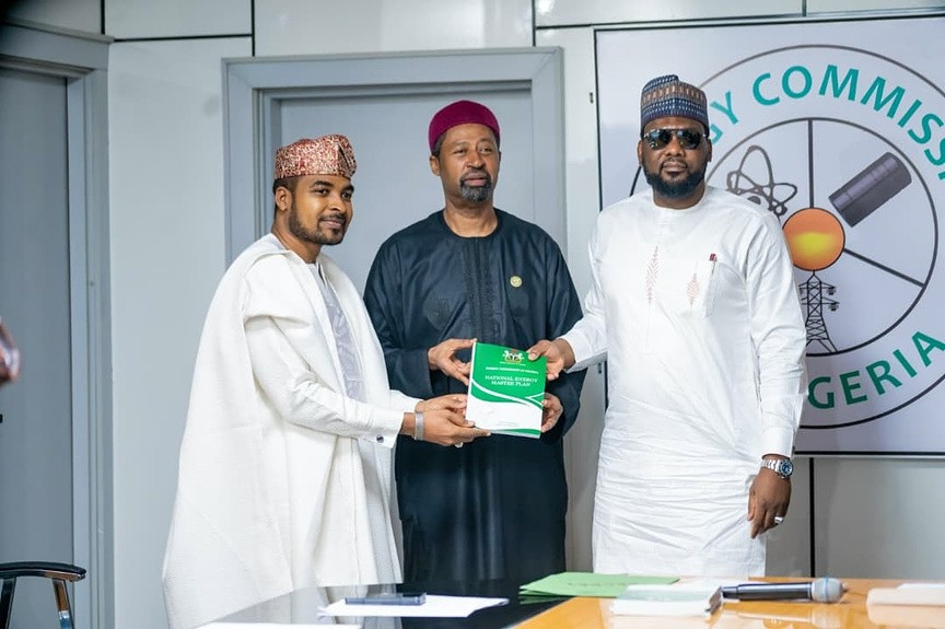 Officials presenting bound copies of the plan under the Energy Commission crest